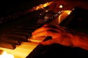 hands playing piano by candlelight